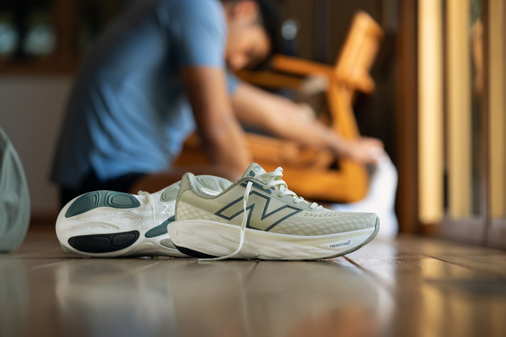 A pair of new balance shoes are sitting on the floor.
