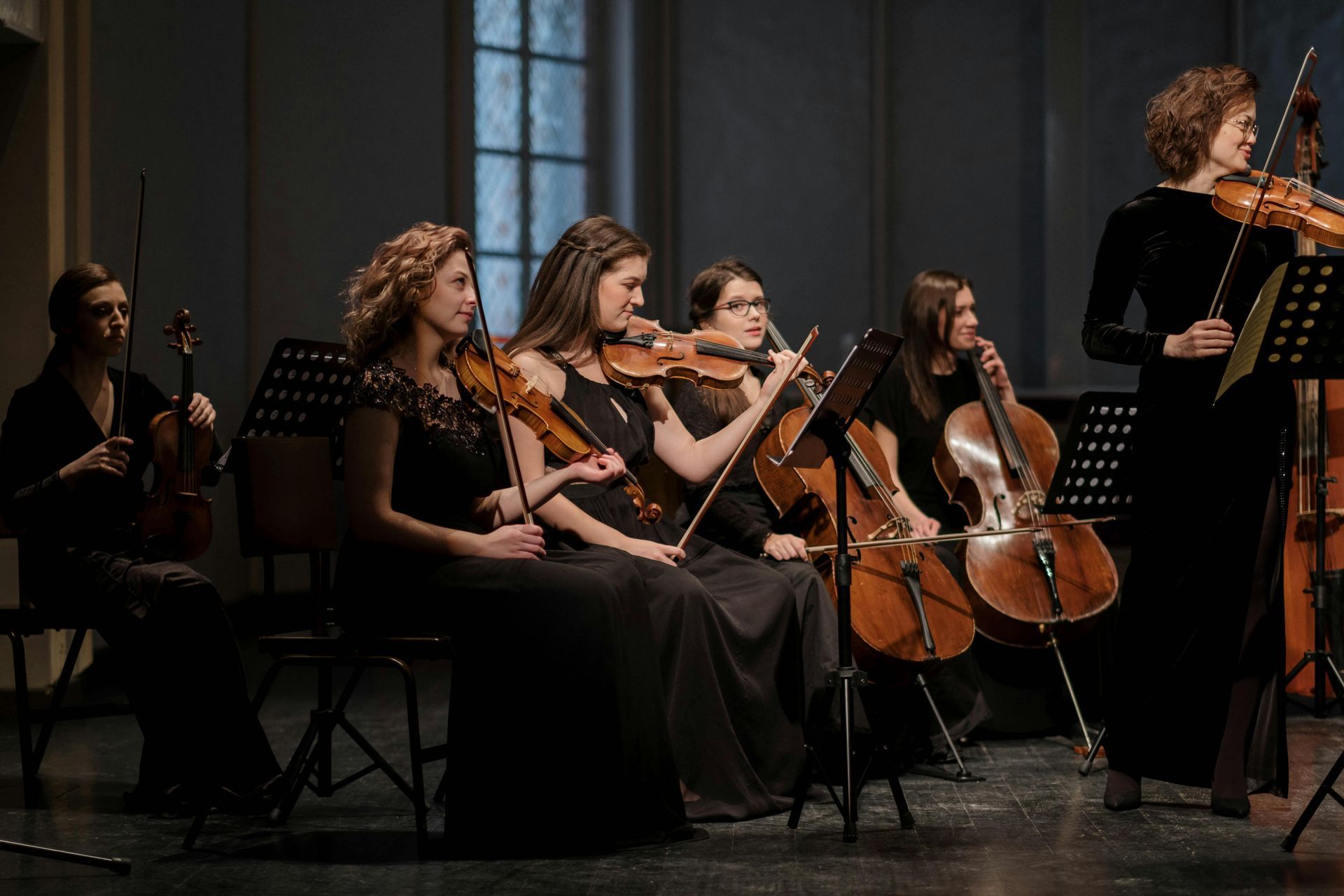 Orkest op het podium: strijkinstrumenten, muzikanten in formele kleding.