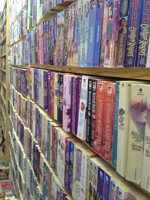 Rows of VHS tapes on shelves in a store, displaying a variety of colors and titles.