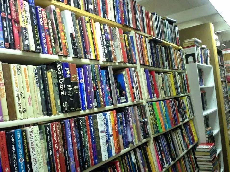 Bookshelves packed with books of varying sizes and colors inside a store.