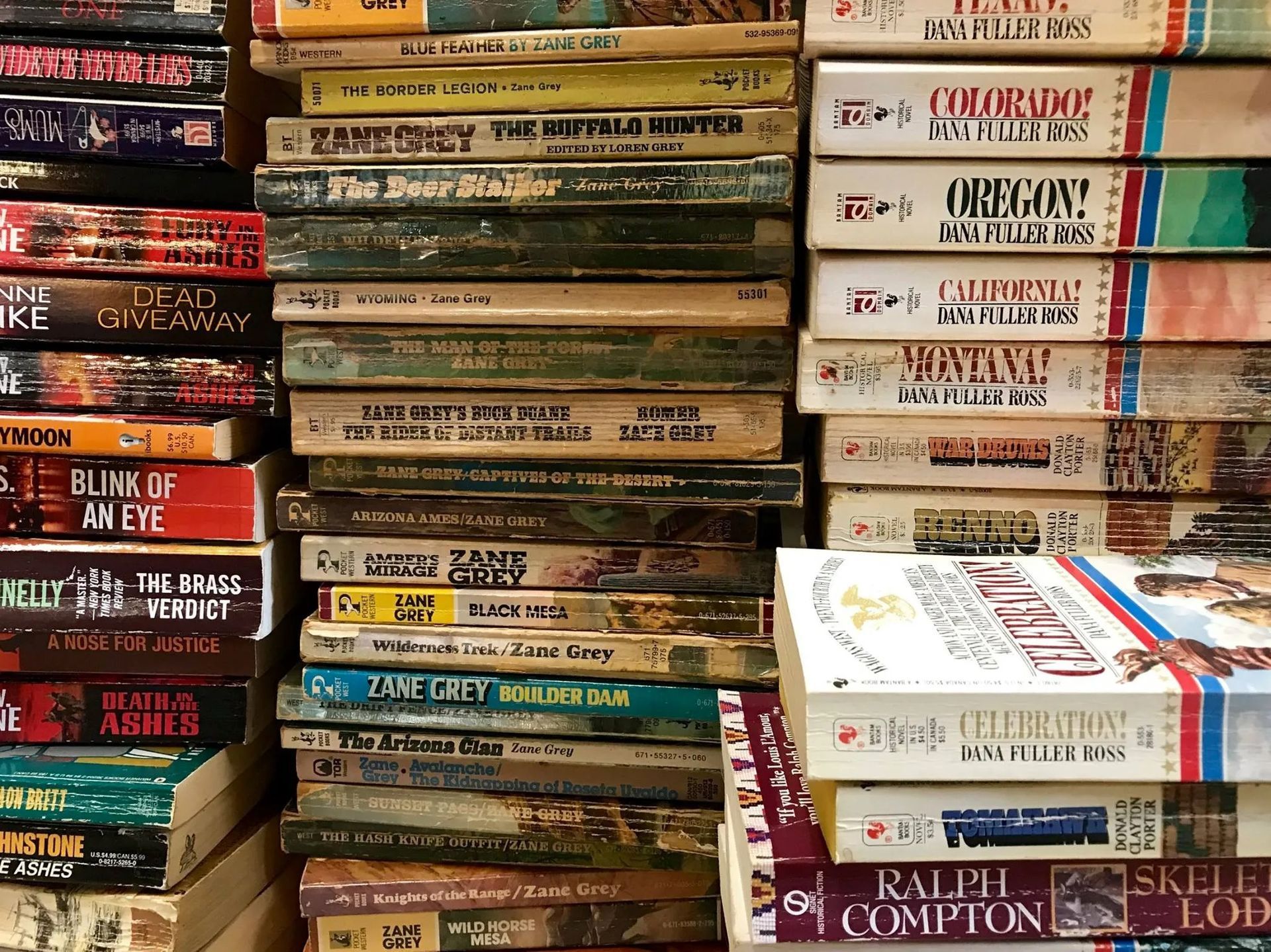 Stacks of old books, many with worn spines and titles like