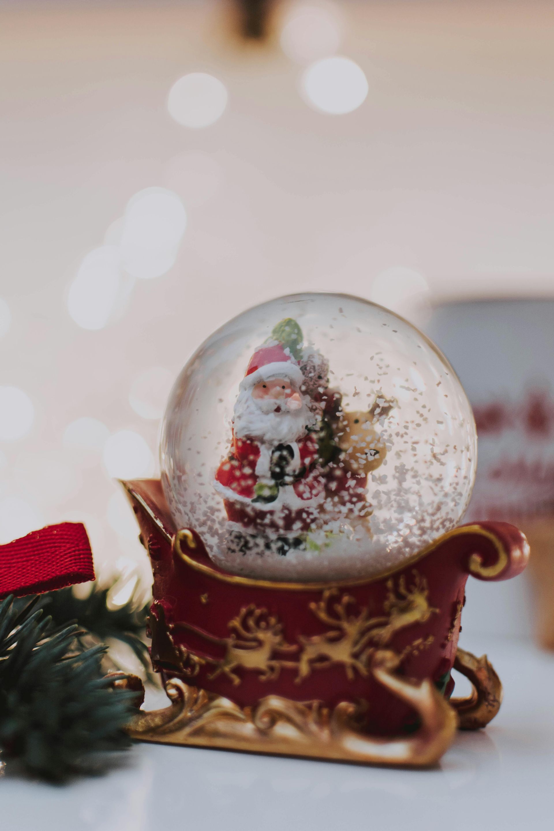 A snow globe with santa claus in a sleigh is on a table.