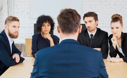A job candidate being interviewed by a panel of four.