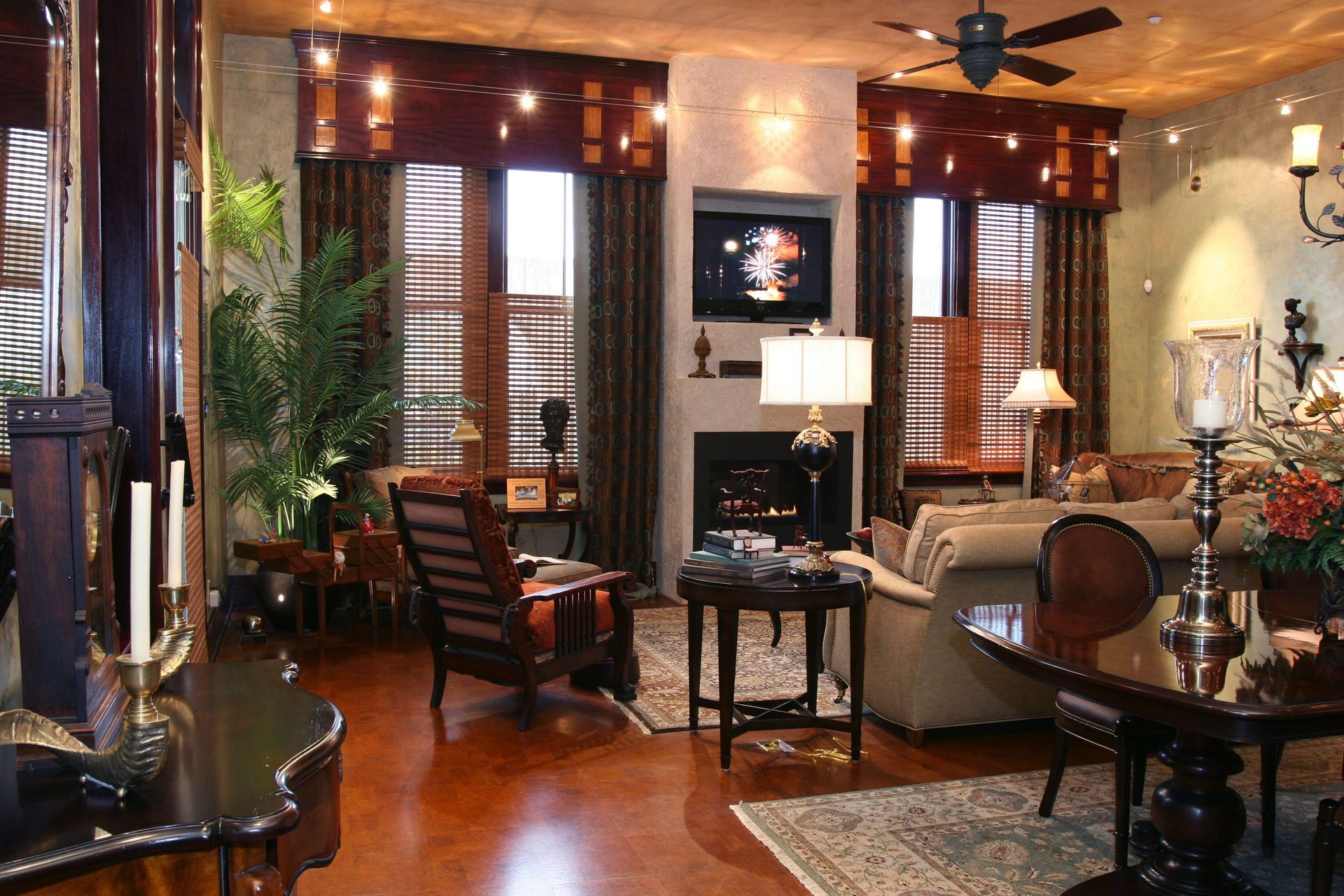 Elegant living room with wood floors, leather chairs, warm lighting, and a fireplace area