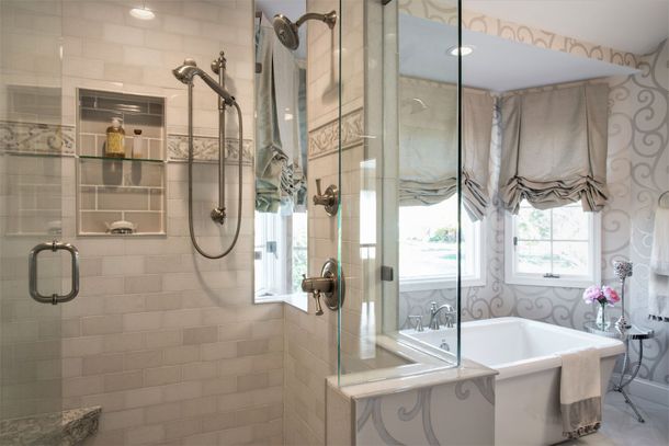 Bright bathroom with glass shower, freestanding tub, and patterned window valance