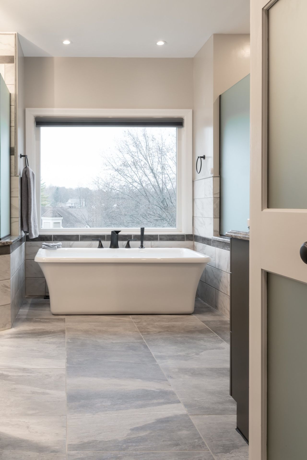 A bathroom with a tub and a window.