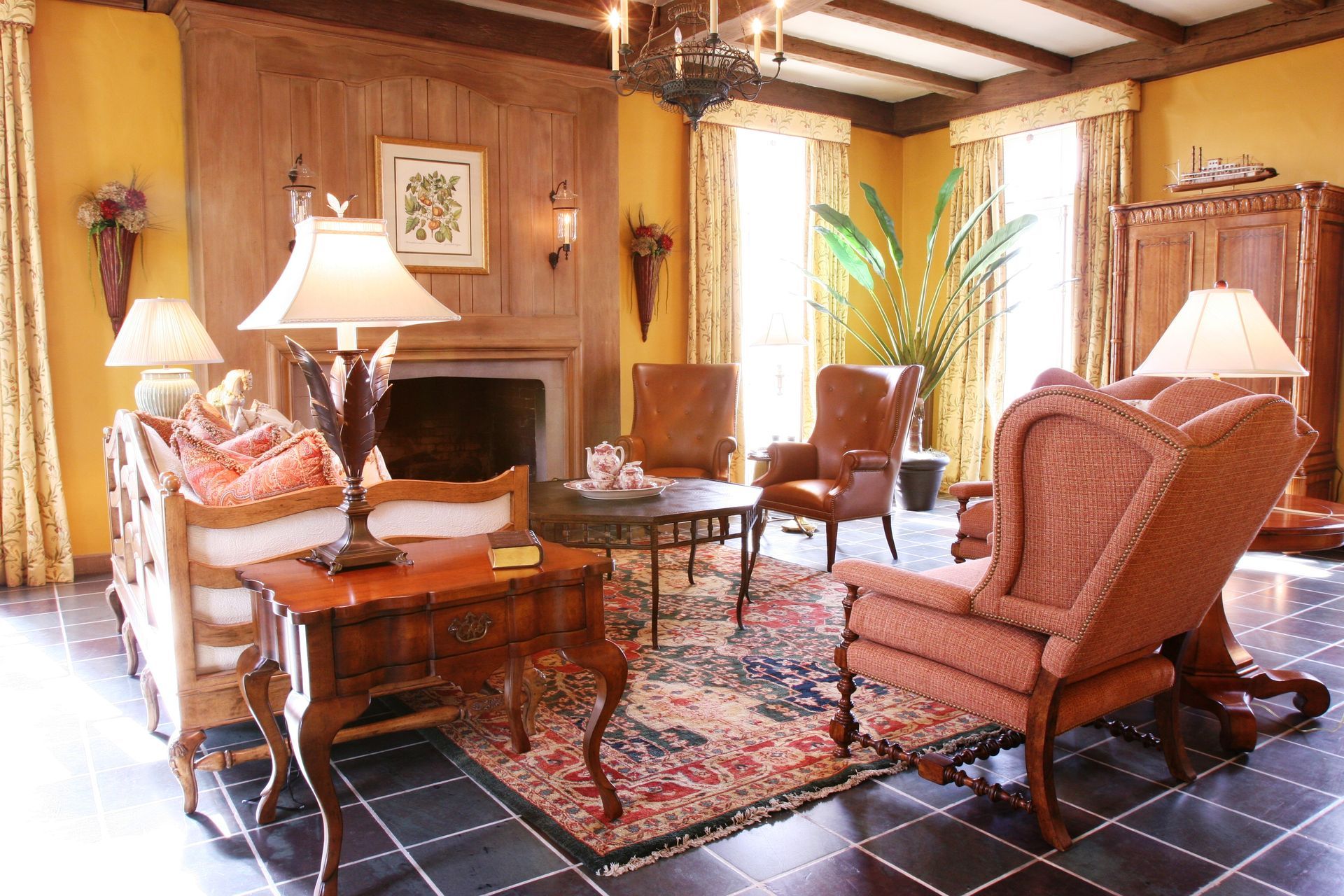 Elegant living room with leather chairs, fireplace, lamps, and patterned rug on tiled floor