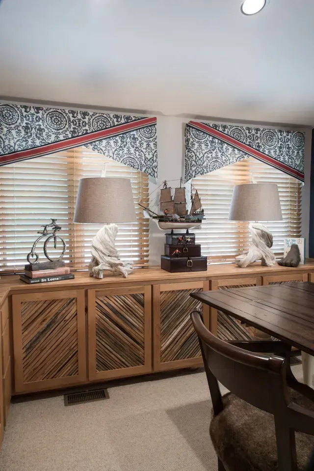 A dining room with a table , chairs and lamps.