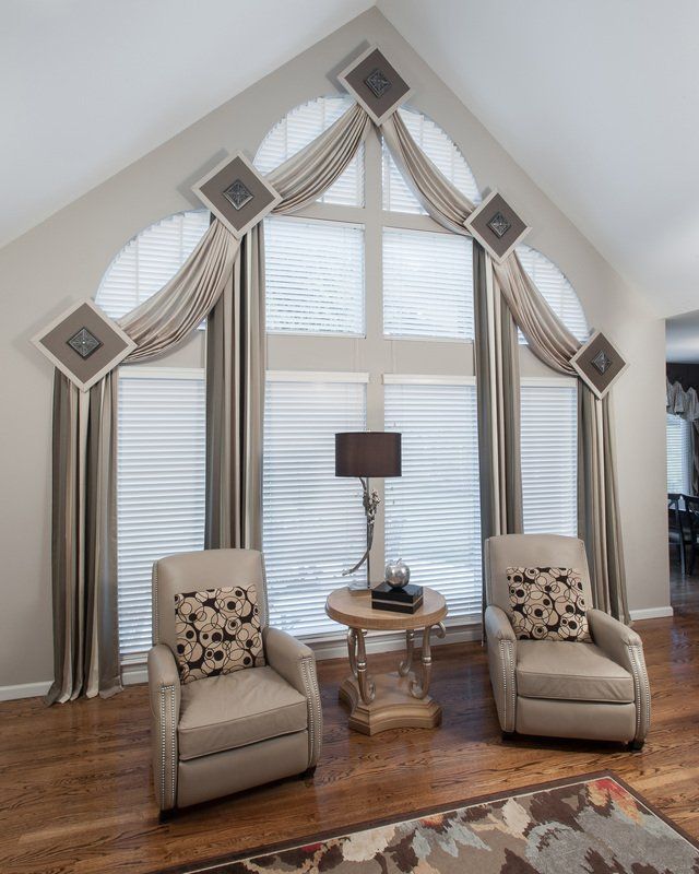 A living room with two chairs a table and a lamp