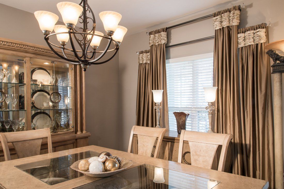 A dining room with a table and chairs and a chandelier.