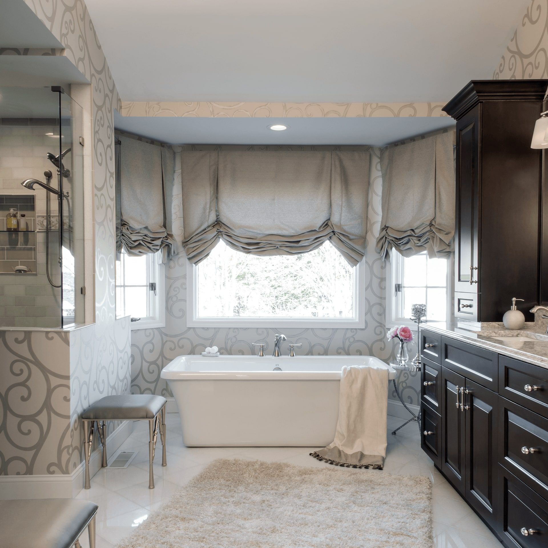 A bathroom with a white tub and black cabinets