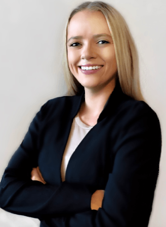 A woman in a black jacket is smiling with her arms crossed.