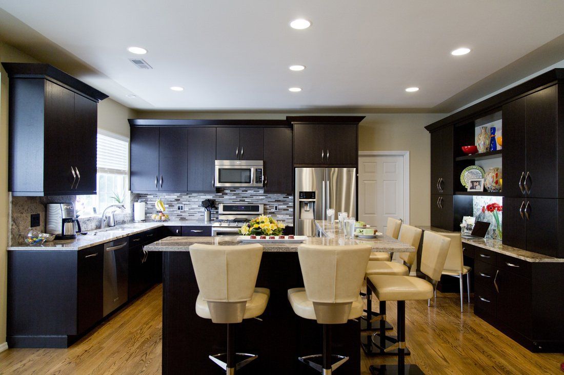 A kitchen with black cabinets and stainless steel appliances