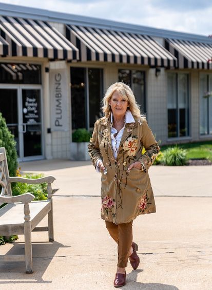 A woman is standing in front of a building that says plumbing