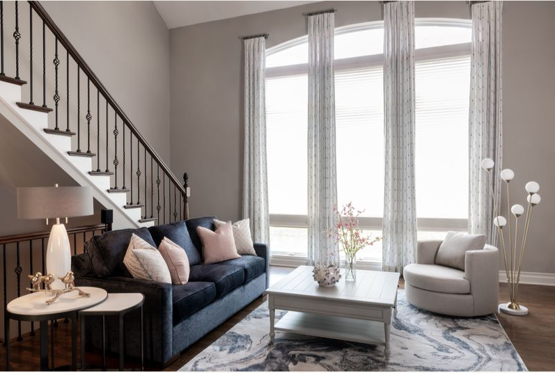 A living room with a couch , chair , coffee table and stairs.