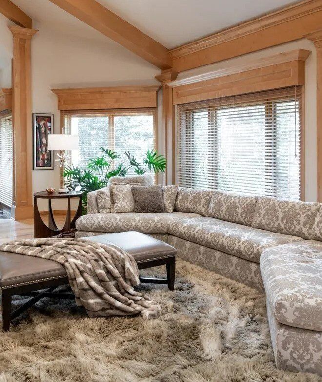A living room with a large sectional couch and ottoman
