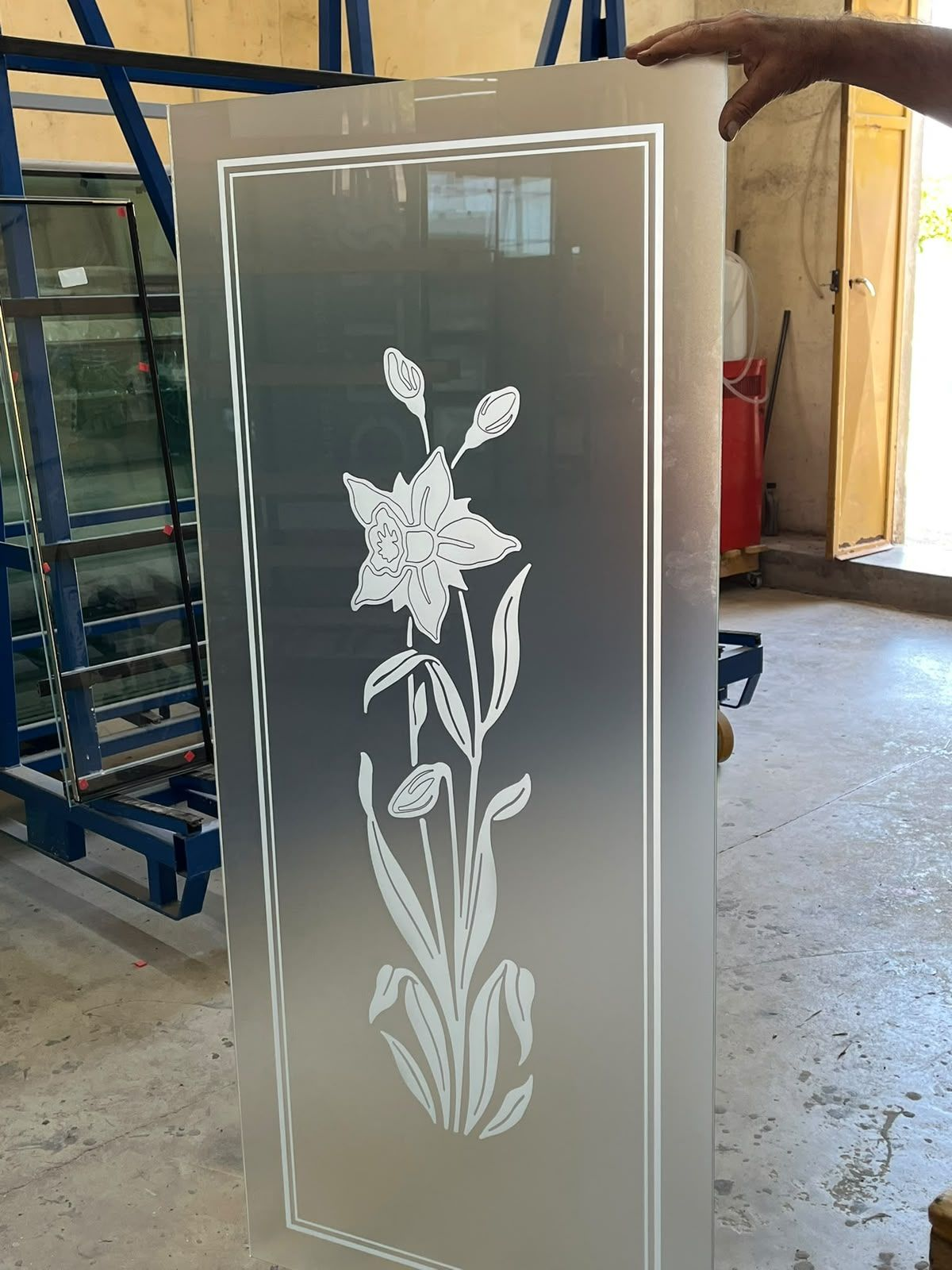 Stretto corridoio con porta in vetro smerigliato dipinta con fiori rossi e steli verdi