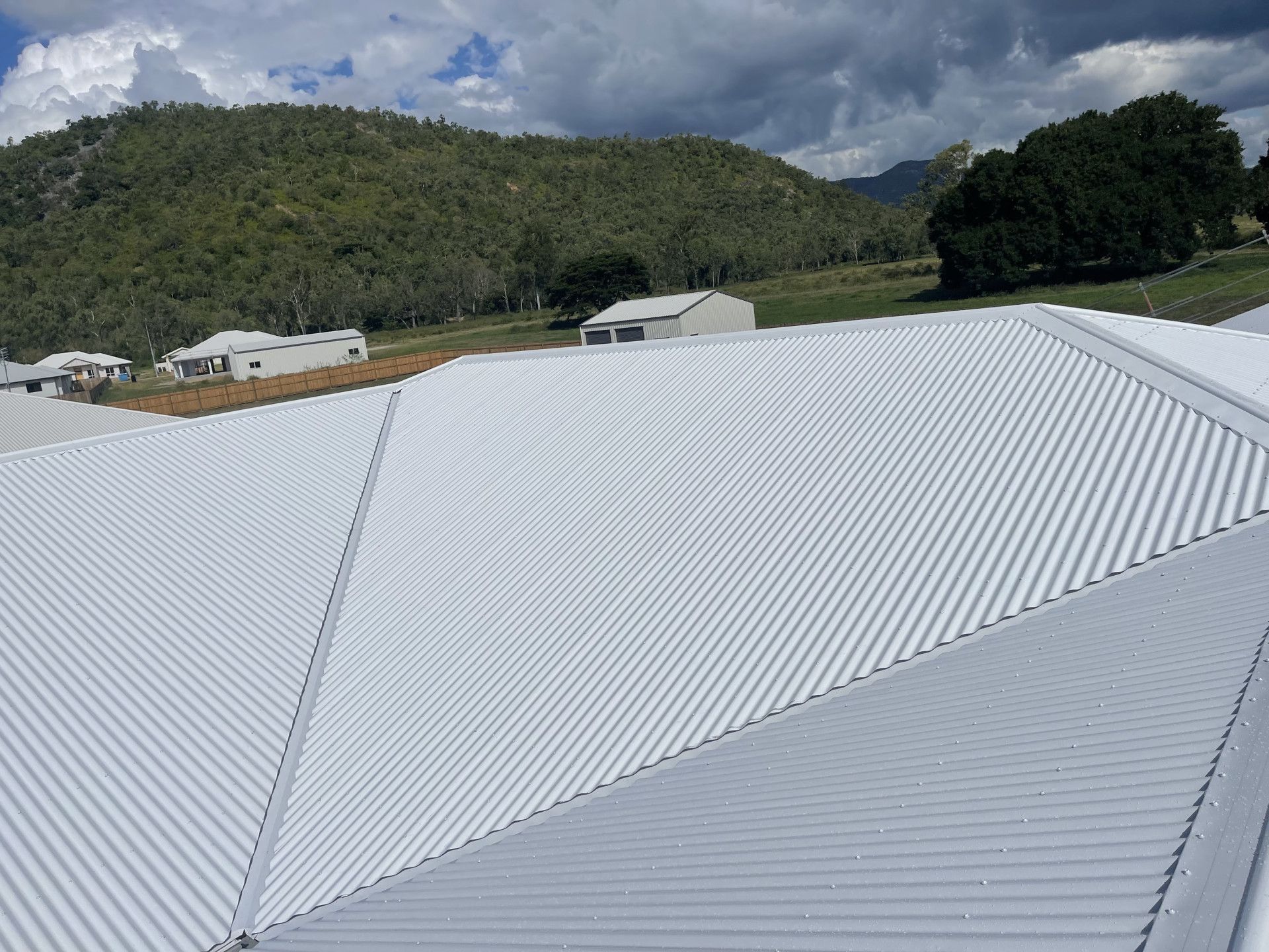 White metal roof with mountains in the background.— Roof 4 U in Rasmussen, QLD