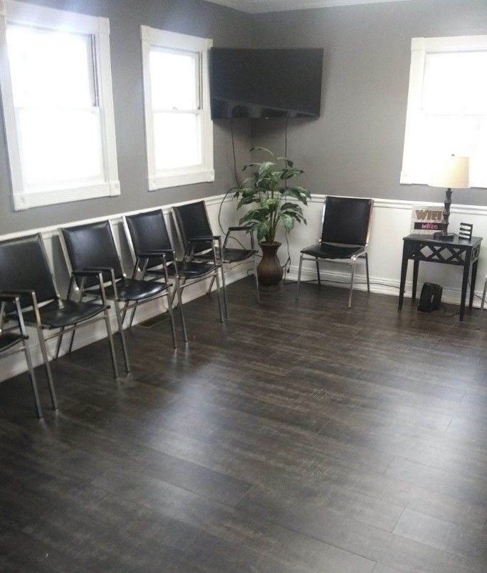A waiting room with chairs and a tv on the wall