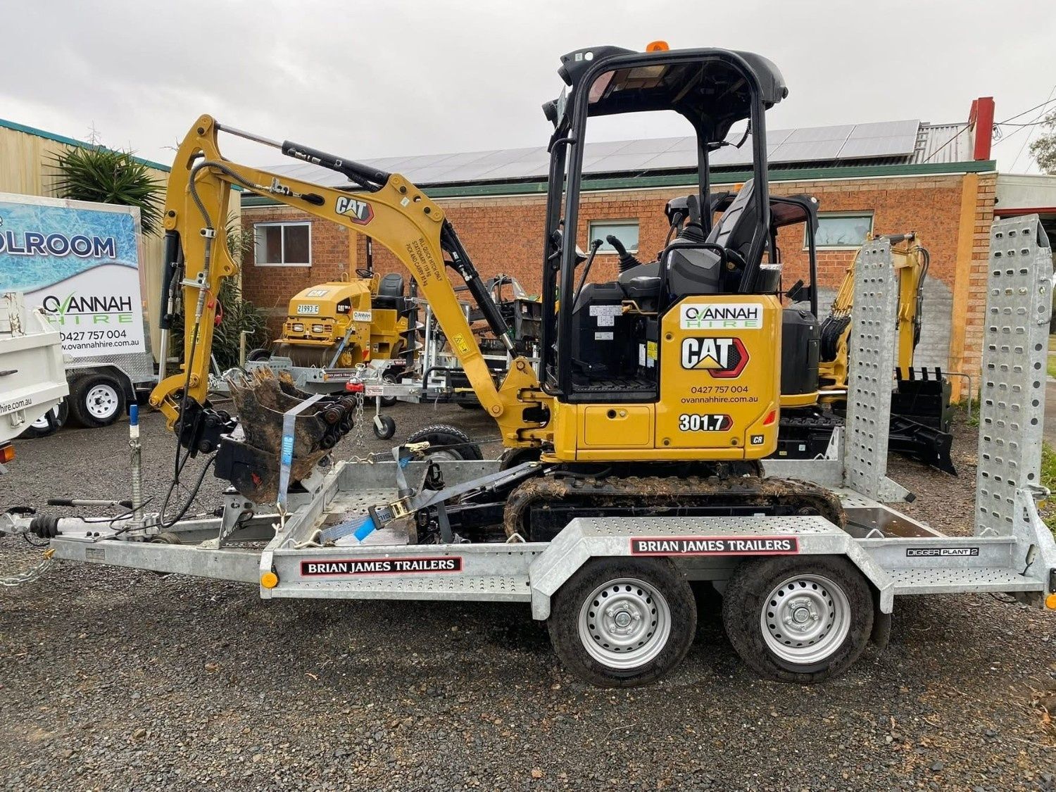 A Yellow Caterpillar Excavator Sits on a Flatbed — Ovannah Hire In West Kempsey, NSW