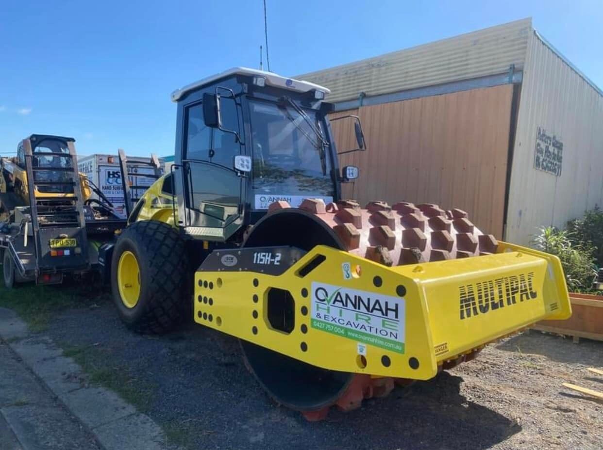 Yellow Construction Roller With Studded Drum, Parked in Front of a Building — Ovannah Hire In West Kempsey, NSW