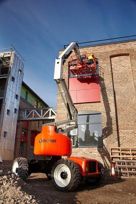 Orange Boom Lift With a Worker at a Building Site — Ovannah Hire In West Kempsey, NSW