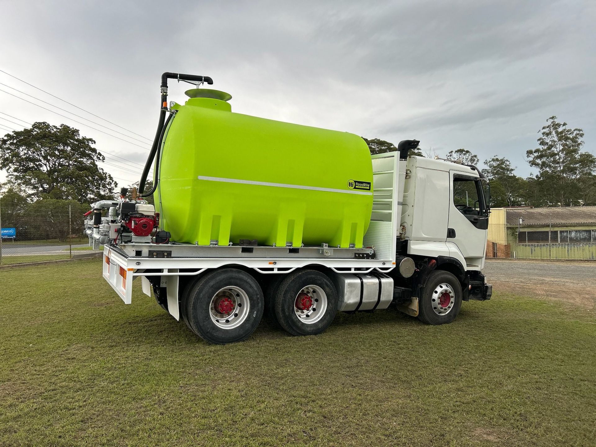Green Water Tank on a White Truck Parked on Grass, Under an Overcast Sky — Ovannah Hire In West Kempsey, NSW