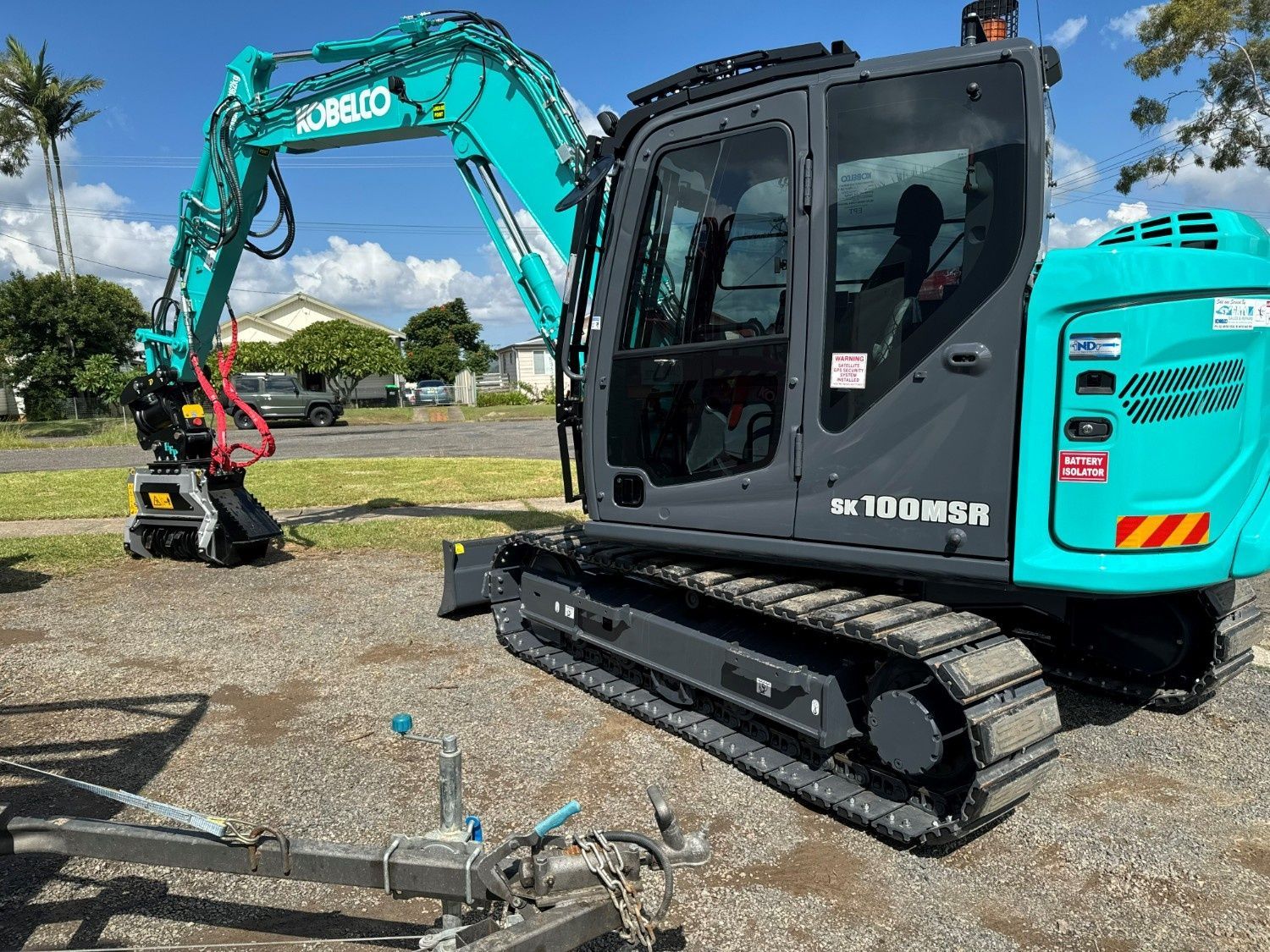 A Teal Kobelco Excavator Parked on a Gravel Lot — Ovannah Hire In West Kempsey, NSW