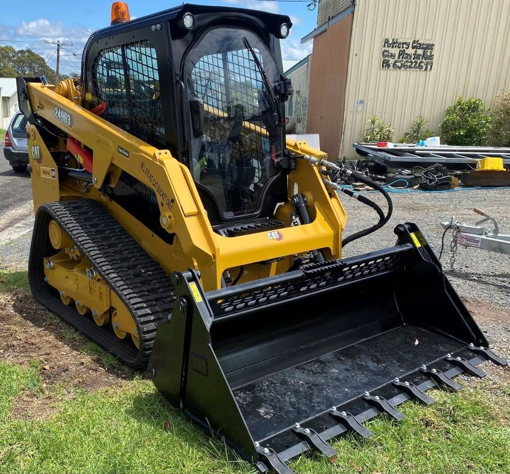 Yellow and Black Skid Steer Loader With Bucket Outdoors on Grass — Ovannah Hire In West Kempsey, NSW