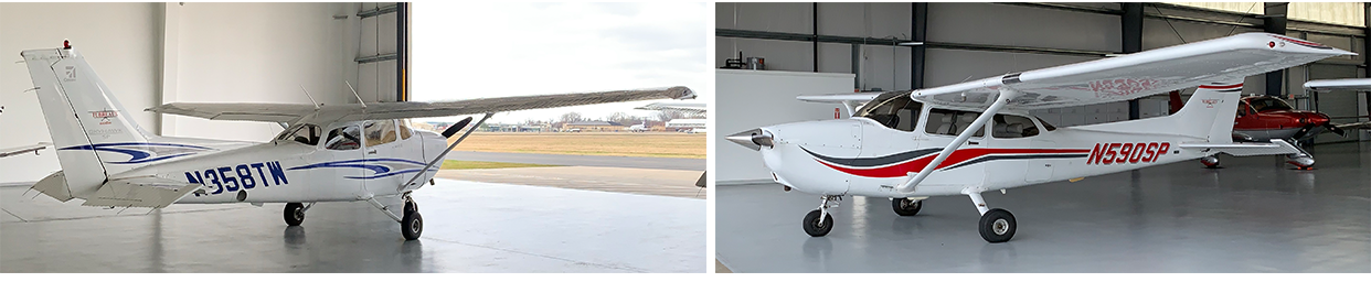 Side-by-side small white-and-red airplanes parked inside a hangar