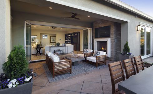 There is a patio with a fireplace and a table and chairs.