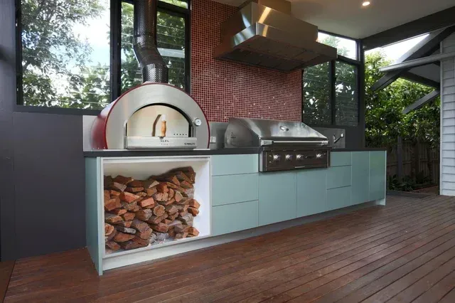 A kitchen with a pizza oven and a grill