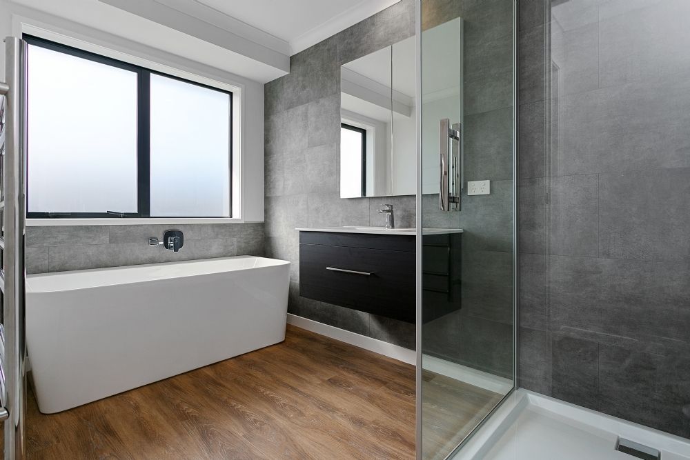 A bathroom with a bathtub , sink , mirror and walk in shower.