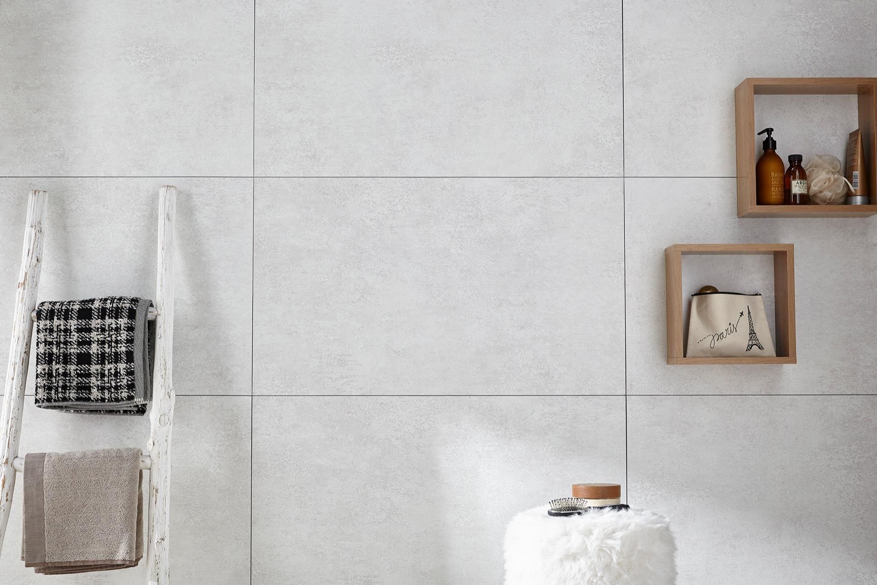 A bathroom with white tiles and wooden shelves