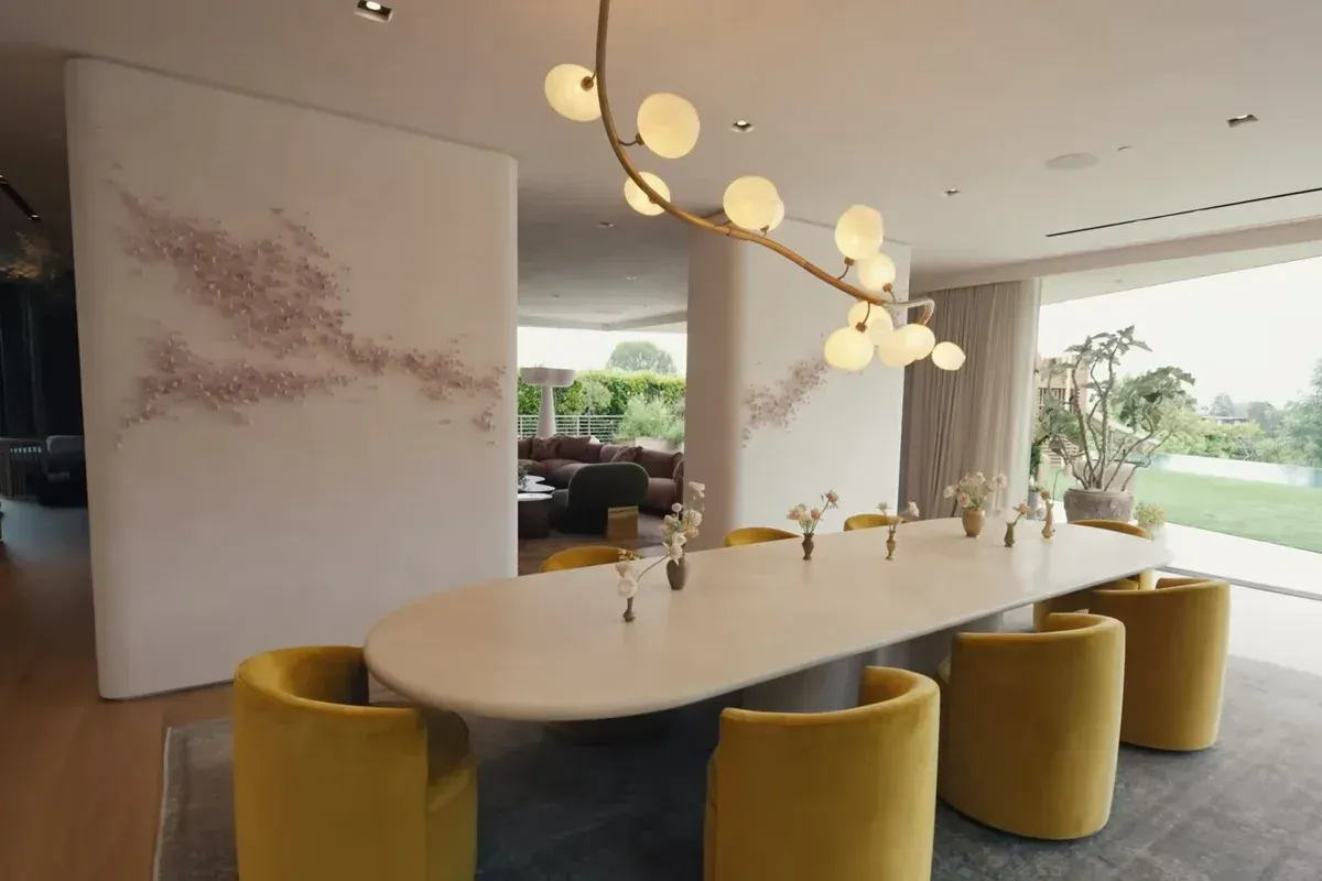 A dining room with a long table and yellow chairs