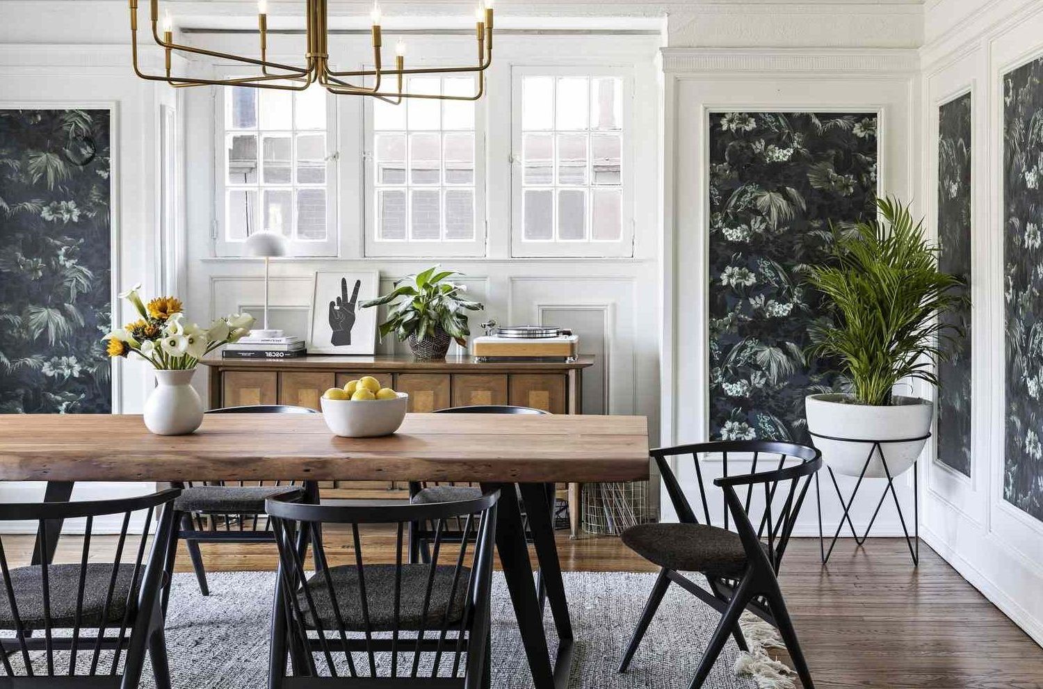 A dining room with a wooden table and chairs and a chandelier.