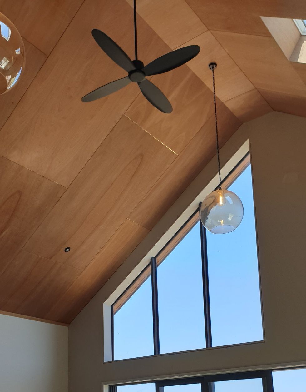 A ceiling fan is hanging from the ceiling above a window