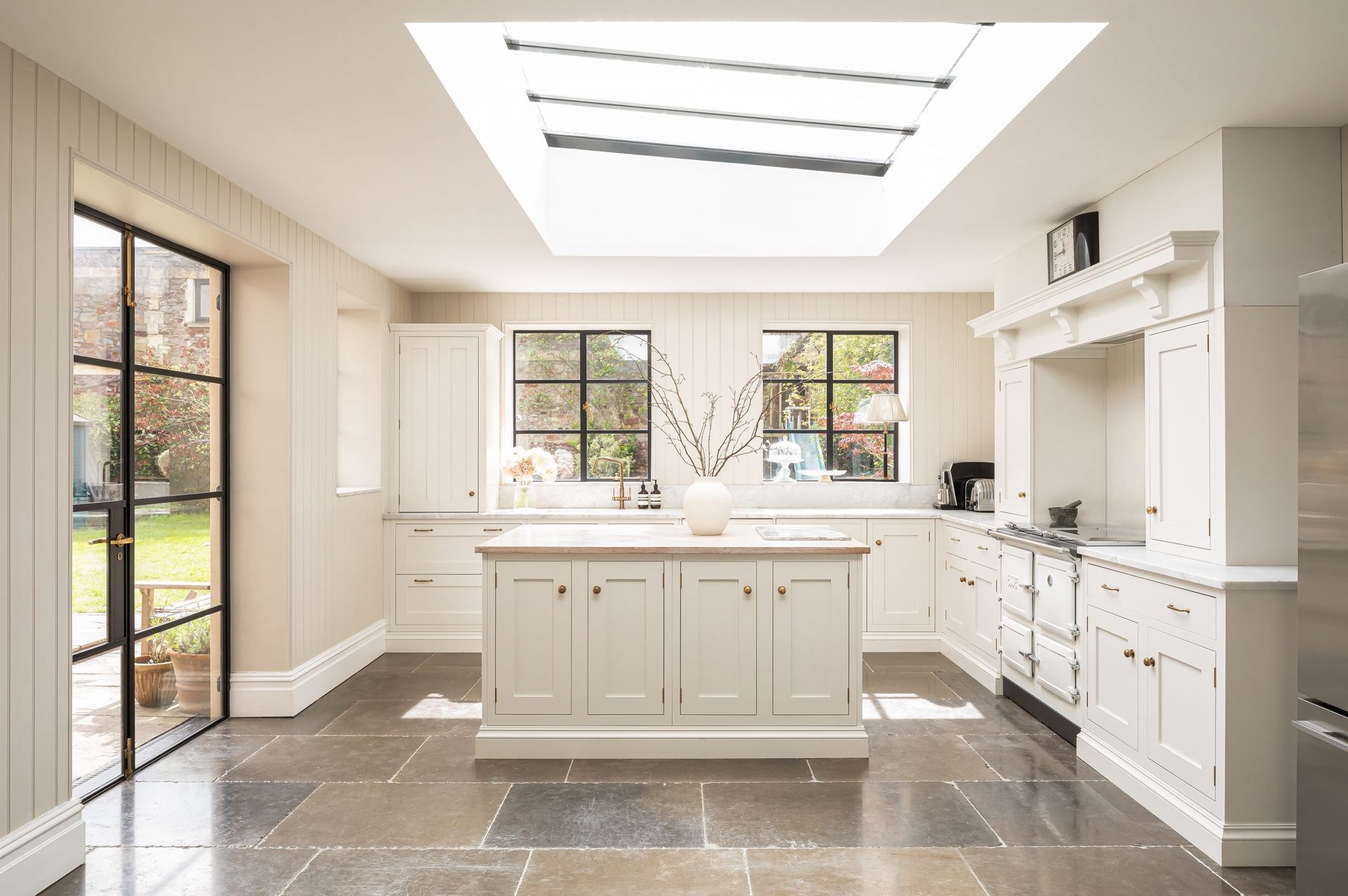 A kitchen with white cabinets and a large island in the middle.