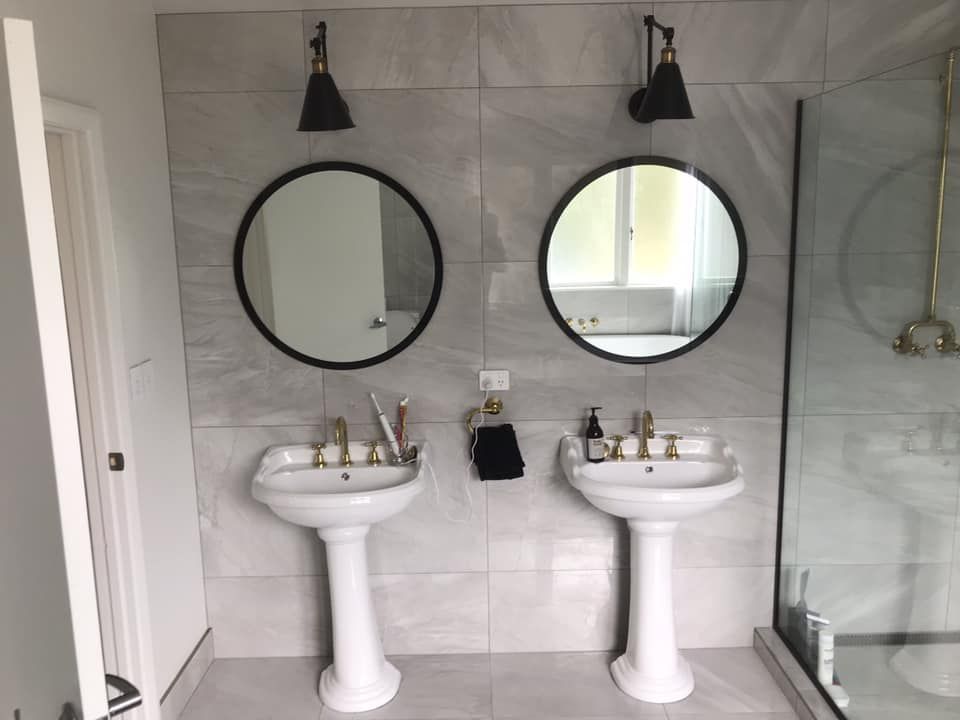 A bathroom with two sinks and two mirrors.
