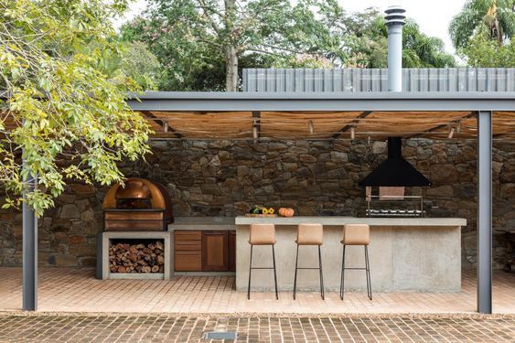 A large outdoor kitchen with a wood oven and a stove.