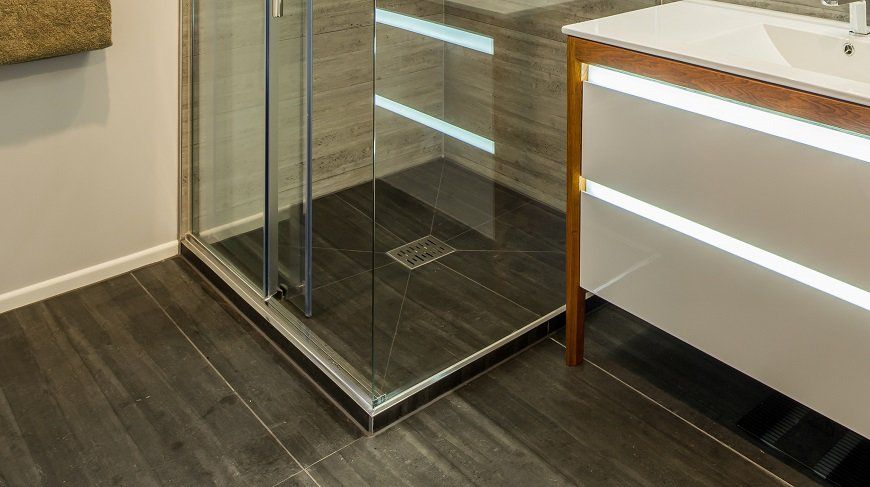 A bathroom with a walk in shower and a sink.