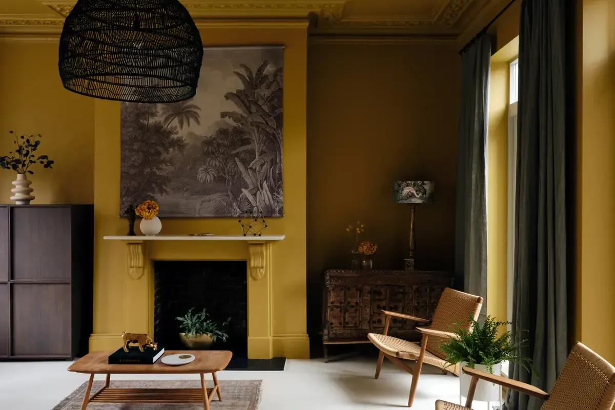 A living room with yellow walls and a fireplace.