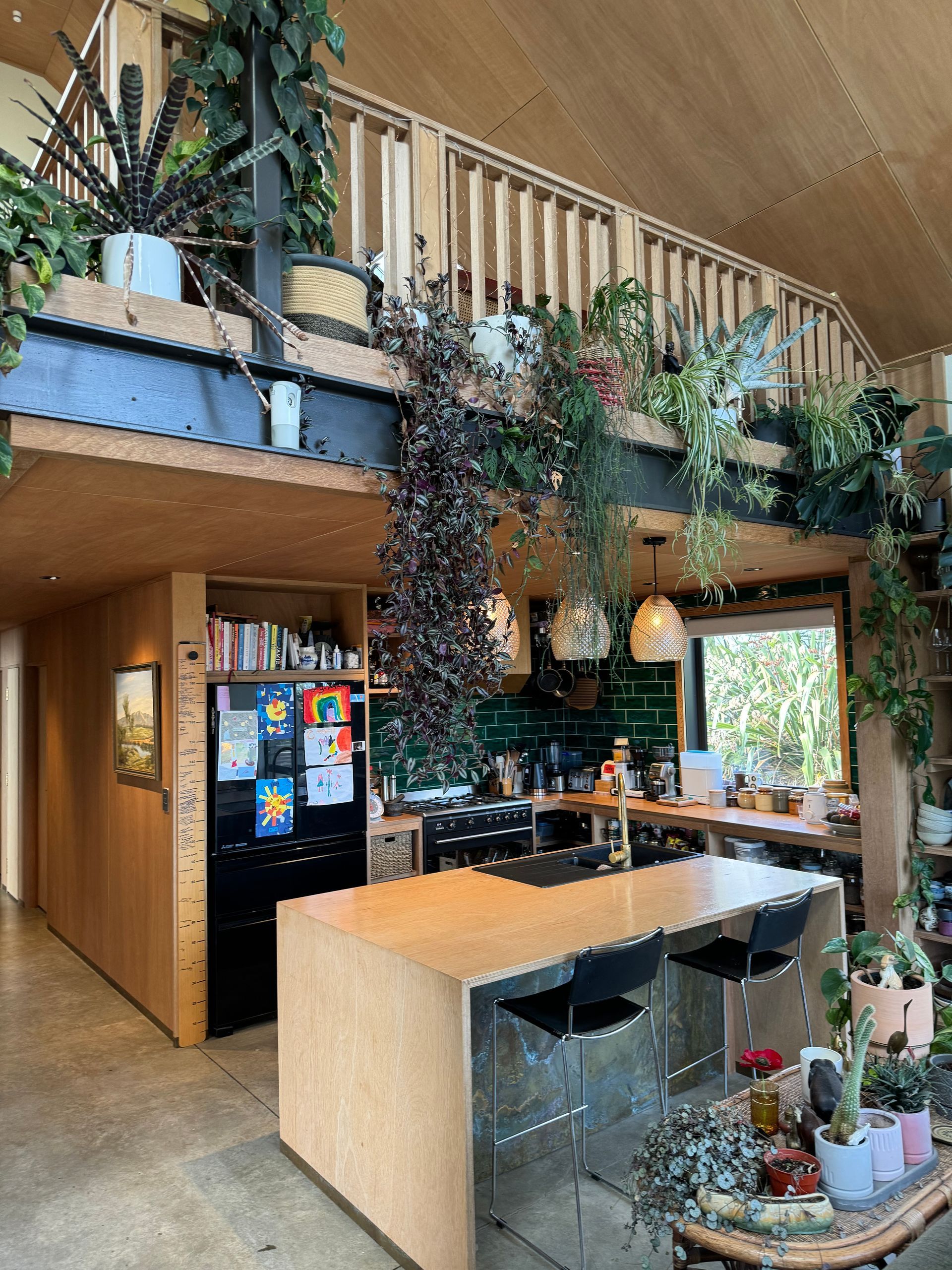 A kitchen with a large island and a black refrigerator.