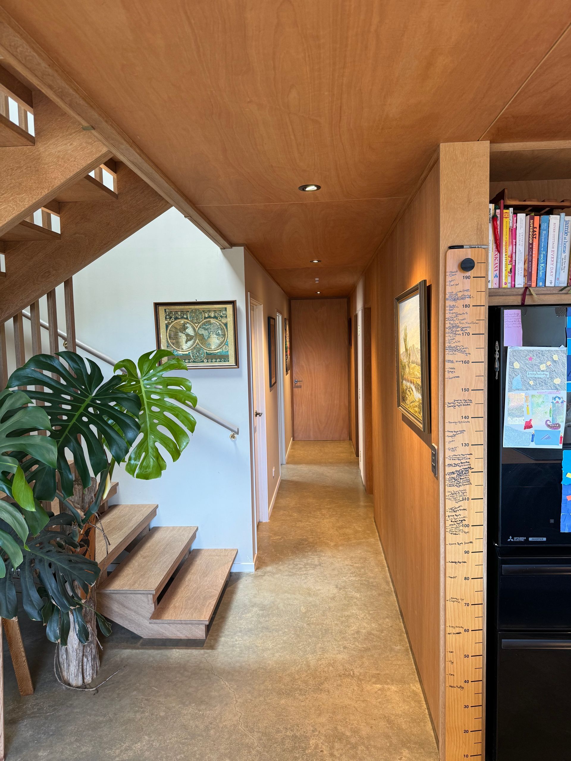 A hallway with stairs and a ruler on the wall