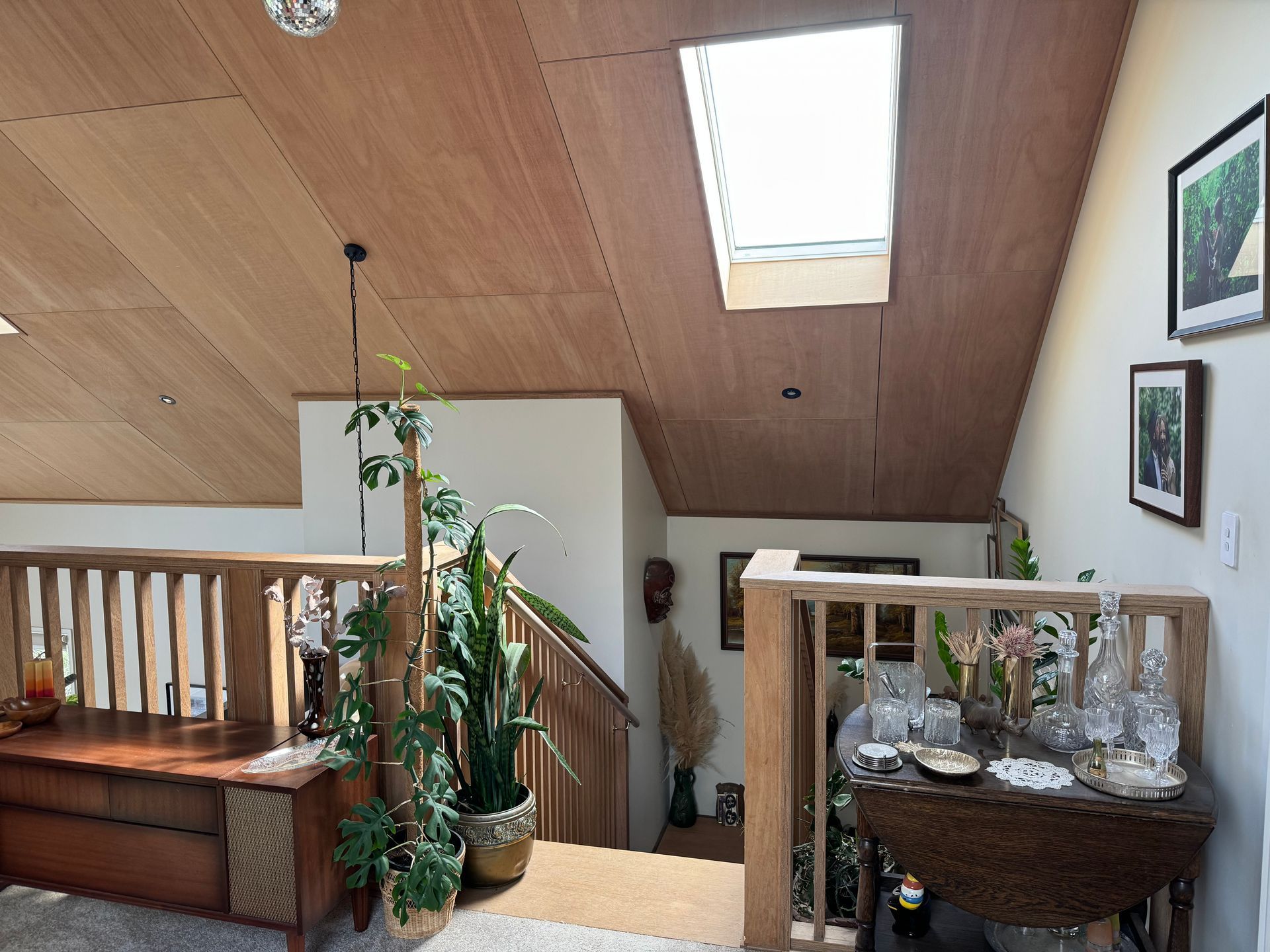 A living room with a wooden railing and a skylight