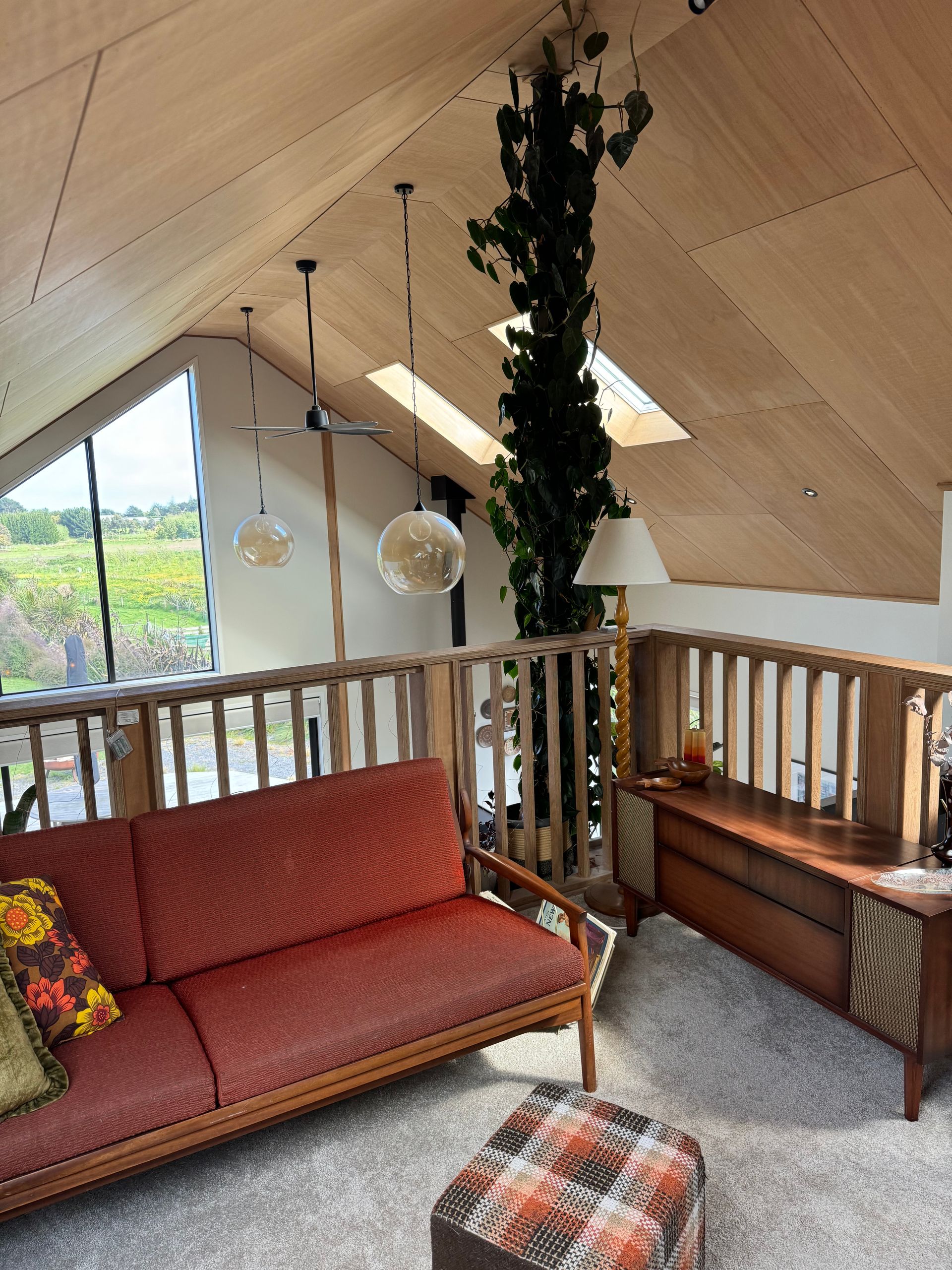 A living room with a red couch and a wooden table
