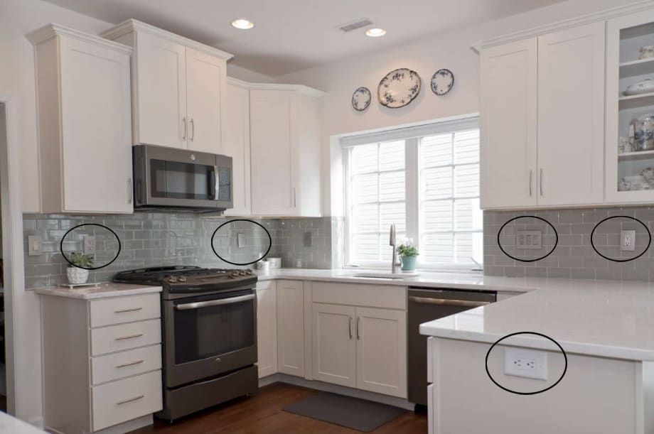 A kitchen with white cabinets , a stove , a microwave , and a sink.