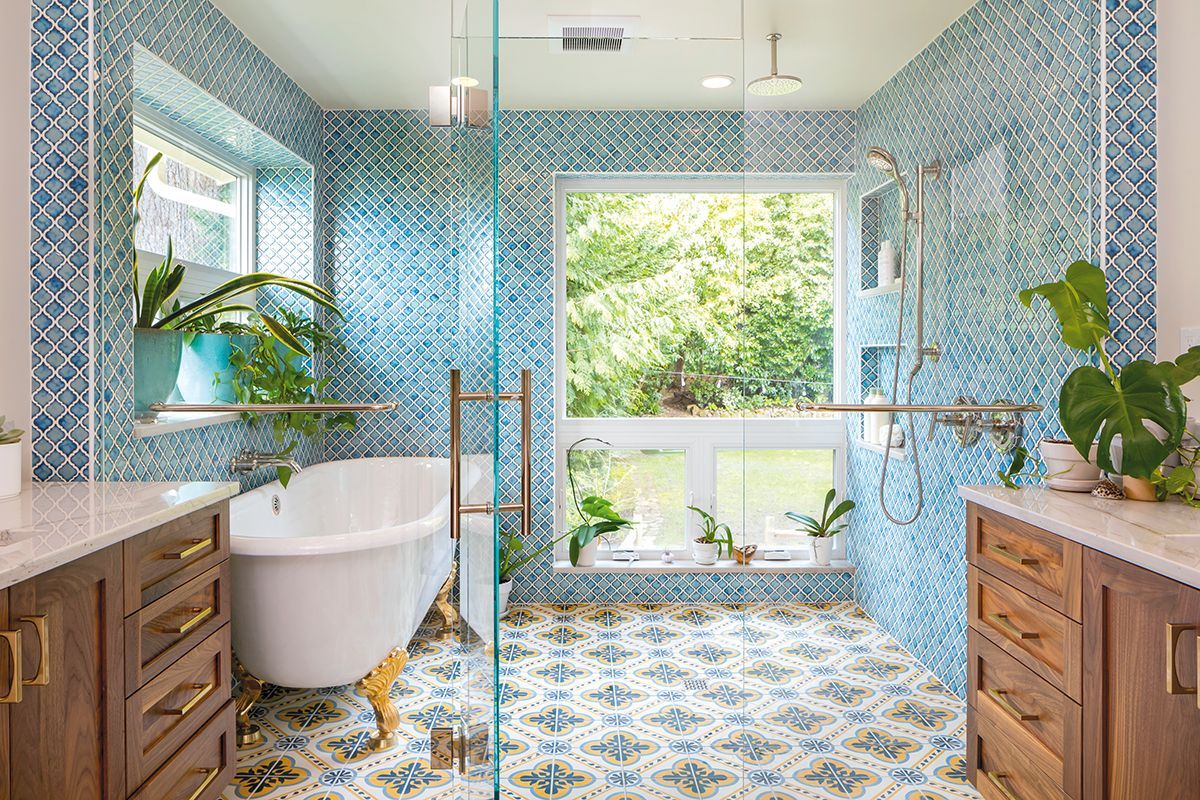 A bathroom with a tub , sink , shower and window.