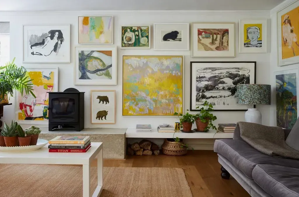 A living room filled with furniture and paintings on the wall.