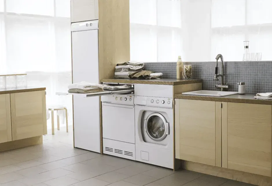 A kitchen with a washer and dryer and a sink